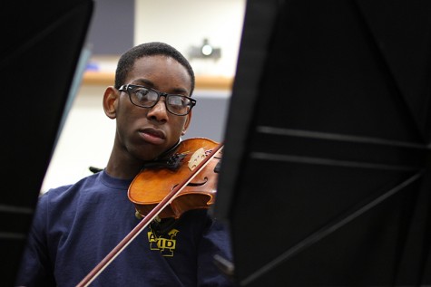 During class junior Josh Snead plays the viola as he reads his sheet music. 