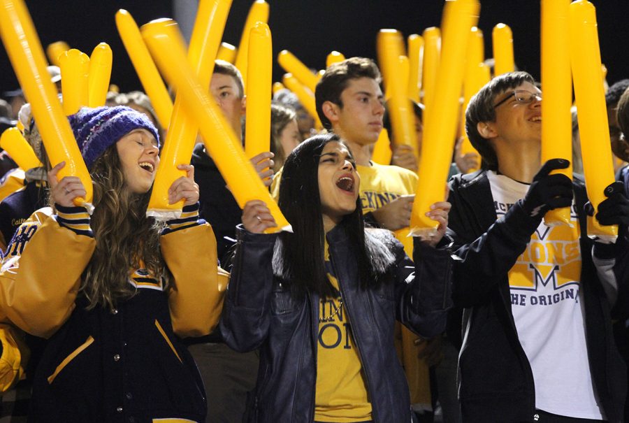 At the start of last Fridays crosstown showdown, seniors Neelam Bohra, Molly Johnson, and Jacob Chow cheer on the Lions.