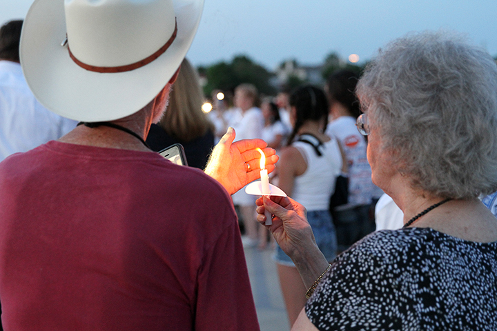 Two community members holding their lit candle.
