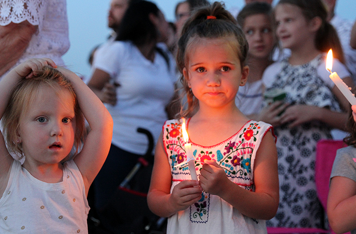 Two children hold their candles.