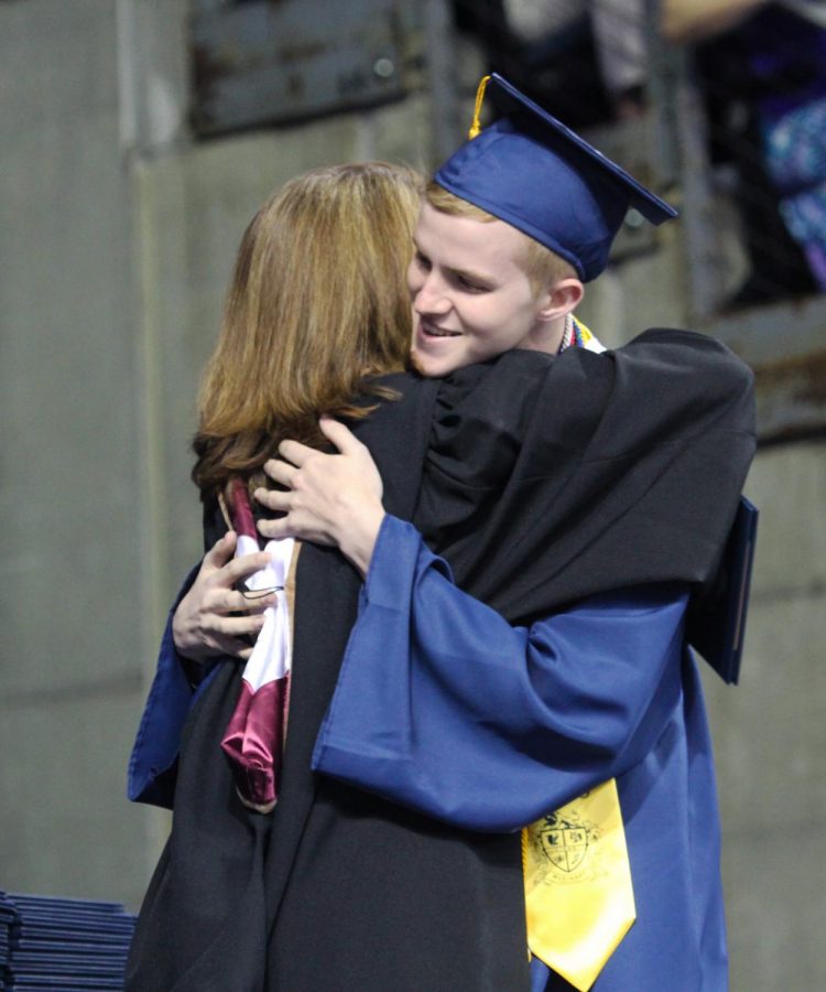 Valedictorian Jacob Harsch hugs school board member Stephanie ODell. 