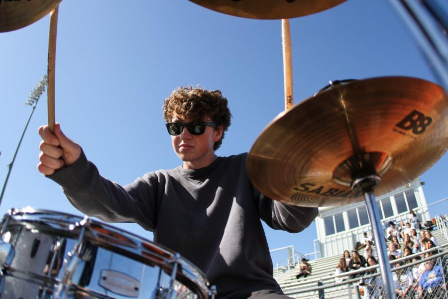 Ian Clark plays the drums for the band Ventura during the homecoming carnival.
