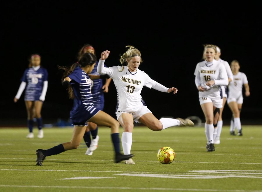 During the soccer game against Sachse High School, senior Madison Lane passes the ball to a fellow teammate. 