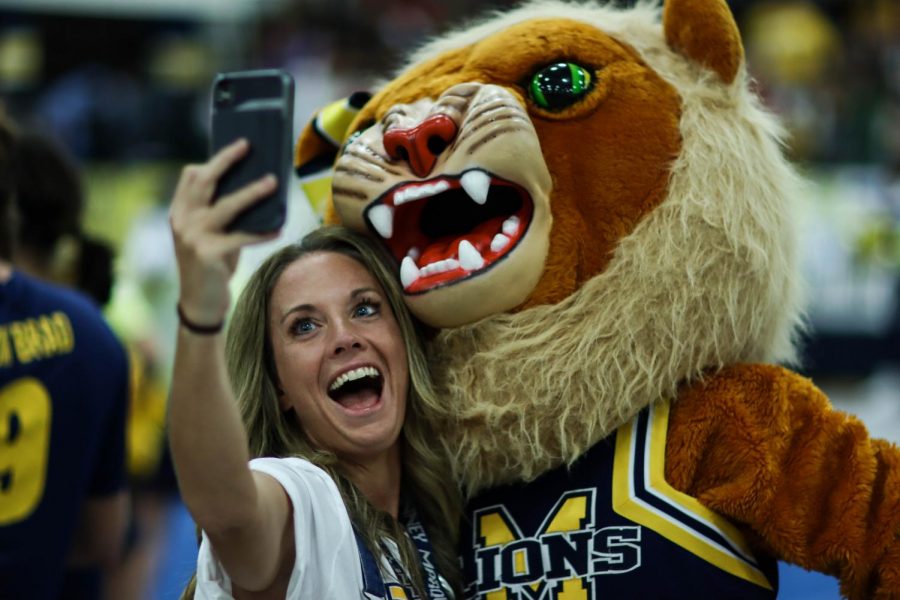 During the first pep-rally, Marquette Director Amy Neely takes a selfie with Leah the Lion. (Sydney Allan)